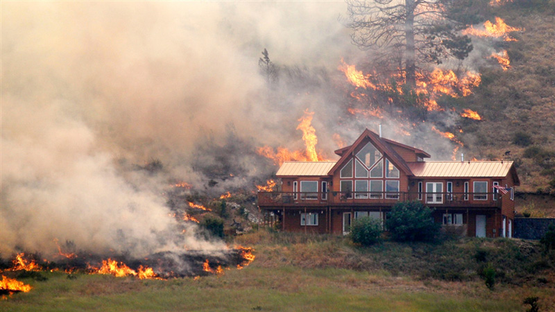 Wildfire approaching a Colorado mountain home in the wildland urban interface